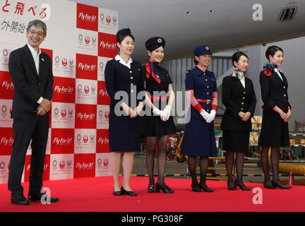 Tokyo, Japan. 23rd Aug, 2018. Japan Airlines (JAL) president Yuji Akasaka (L) smiles with cabin attendants in uniforms of (2nd L-R) third, fifth, sixth, eighth and current generations as he announces the business strategy for 2020 at a JAL hangar of the Haneda airport in Tokyo on Thursday, August 23, 2018. JAL will invest 10 billion yen to improve airport facilities and will change their uniforms in 2020. Credit: Yoshio Tsunoda/AFLO/Alamy Live News Stock Photo