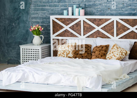 Bedroom with double bed, brick gray wall, loft style. Stock Photo