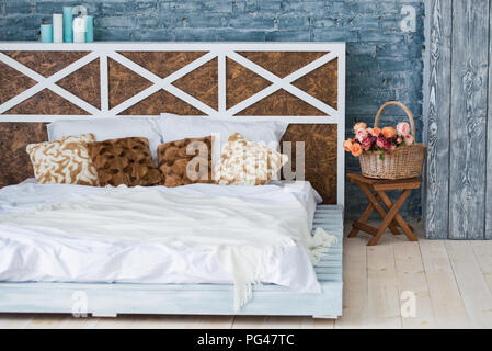 Bedroom with double bed, brick gray wall, loft style. Stock Photo