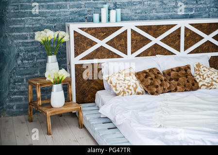 Bedroom with double bed, brick gray wall, loft style. Stock Photo