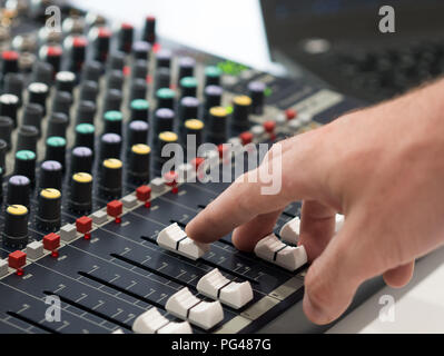 Audio engineer working on mixing console in music studio Stock Photo