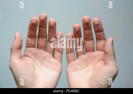 Top view of two empty hands over grey background. Wrinkled palms panhandle concept Stock Photo