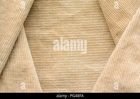 Texture of Beige Velvet Clothes. Geometric Pattern Neatly Stacked Textile Fabric of Corduroy as Blank Background for Your Design Stock Photo