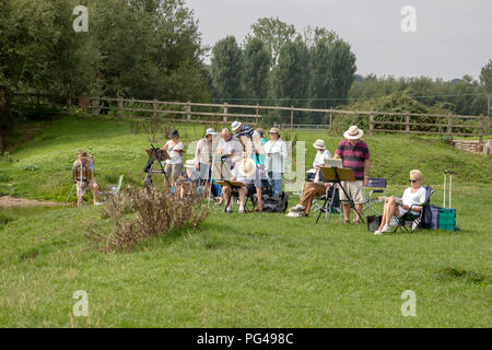 A group of people painting a scene on the banks of the River Stour, Dedham. On the border of Essex and Suffolk Stock Photo