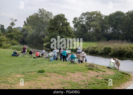 A group of people painting a scene on the banks of the River Stour, Dedham. On the border of Essex and Suffolk Stock Photo