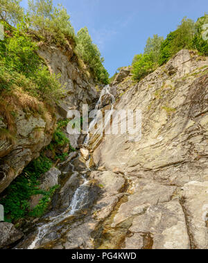 view of waterfall on steep rock ravine , shot on a bright summer day at Gressoney Saint Jean,  Lys valley, Aosta, Italy Stock Photo