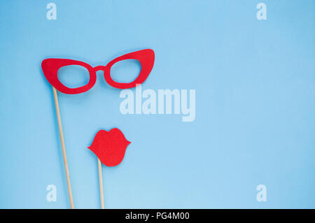 Red bright photo booth props glasses and lips on blue background with copyspace. Stock Photo