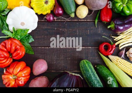 Fresh vegetables harvested from the garden on a dark wooden background. Free space for your project. Food background. Stock Photo