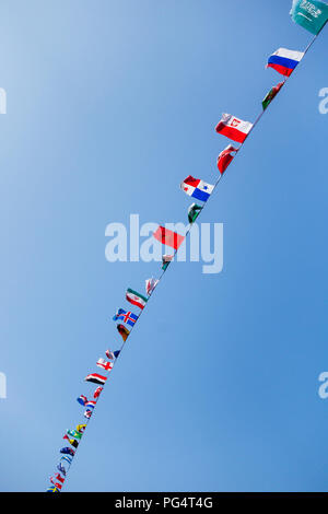 Flags of many countries on a line of bunting, seen against a clear blue sky Stock Photo