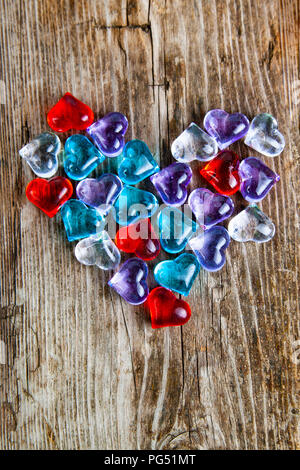 Heart of multi-colored glass hearts  on an old wooden background. Romantic background. Stock Photo