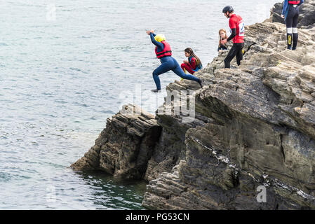 Holidaymakers coasteering on The Headland in Newquay, Cornwall. Stock Photo