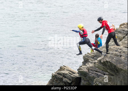 Holidaymakers coasteering on The Headland in Newquay, Cornwall. Stock Photo