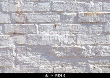 Detail of old brick wall painted white and distressed, peeling and stained. Ideal for grunge background texture Stock Photo