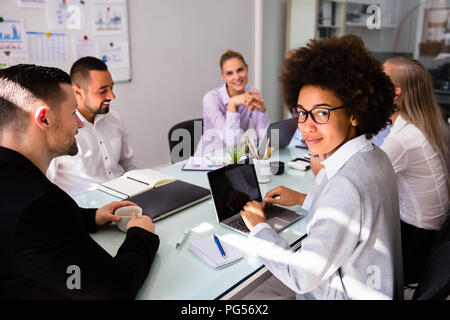 Portrait Of A Smiling African Businesswoman Working On Laptop Stock Photo