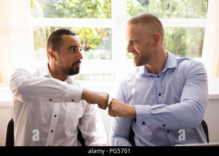 Close-up Of Two Happy Male Making Fist Bump Stock Photo