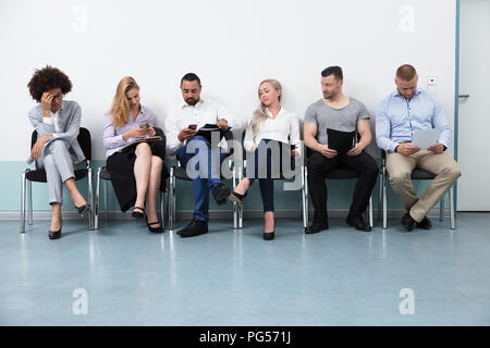 Candidates Sitting On Chair Waiting For An Interview Stock Photo