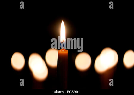 Light candle burning brightly in the black background Stock Photo