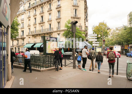 Paris street scene in 15th arrondissement - pedestrians waiting to cross Avenue Felix Faure road at zebra crossing next to Boucicaut Metro Station . .. Stock Photo