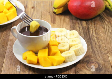 Chocolate fondue and fresh cut fruit Stock Photo