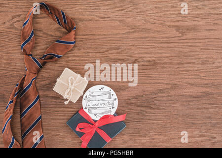 top view of tie with gifts and Happy fathers day greeting on wooden surface Stock Photo