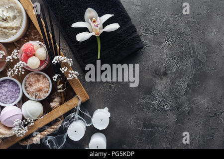 top view of beautiful orchid, towel, candles and spa accessories on grey Stock Photo