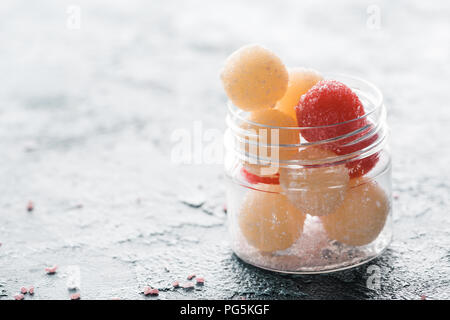 Close-up view of homemade scrub balls in glass container on grey Stock Photo