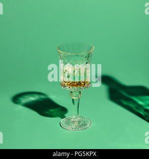 close-up shot of crystal glass of absinthe on green surface Stock Photo