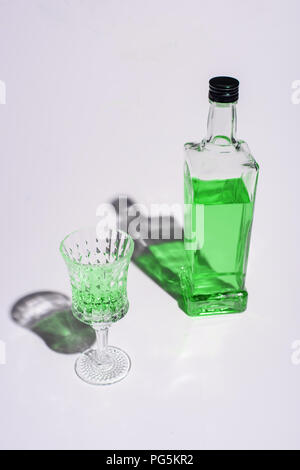 crystal glass and bottle of absinthe on white Stock Photo