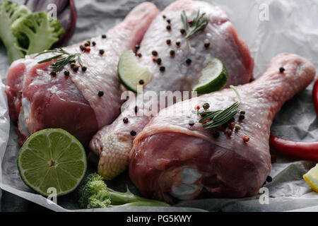 uncooked turkey legs with pepper corns, rosemary and lime on baking paper Stock Photo