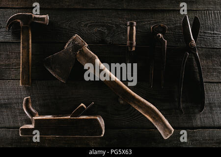 flat lay with arrangement of vintage rusty carpentry tools on wooden tabletop Stock Photo