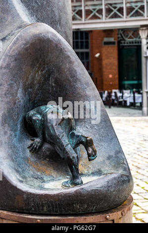 A detail of an outside metal art work showing a man crawling into a hole at the Stary Browar shopping centre in Poznań (Poznan), Poland Stock Photo