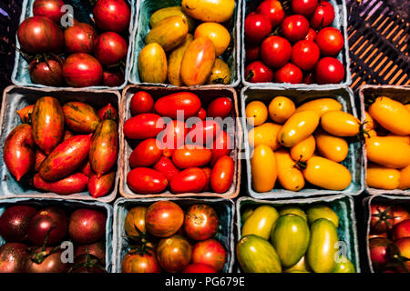 Green, yellow and red grape tomatoes on the farm stand Stock Photo