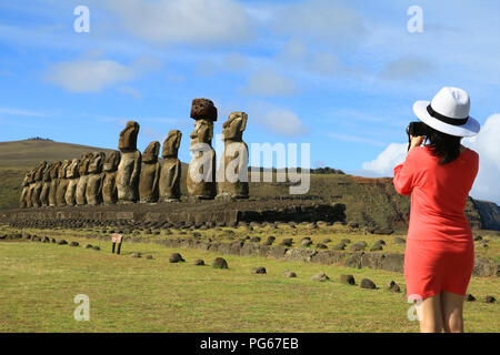 Young woman taking pictures of the famous Moai statues at Ahu Tongariki on Easter Island, Archaeological site in Chile Stock Photo