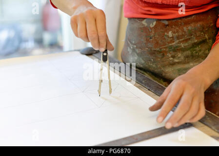 Close-up of woman working on draft in glazier's workshop Stock Photo