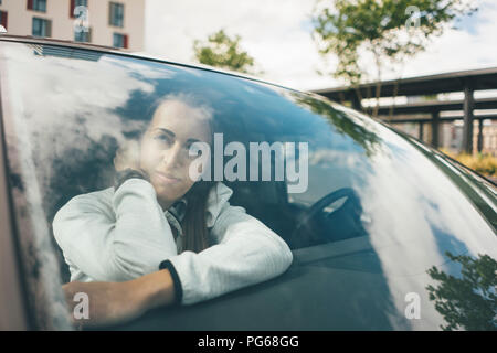 Sportive young woman in car looking out of window Stock Photo