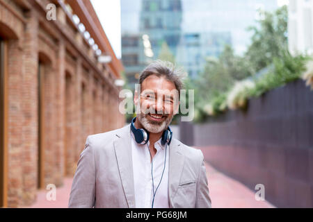 Portrait of laughing businessman with headphones Stock Photo