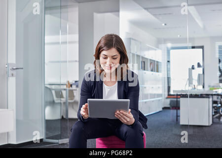 Young businesswoman using tablet in office Stock Photo