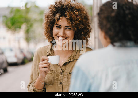Two friends drinking coffee, exchanging news Stock Photo