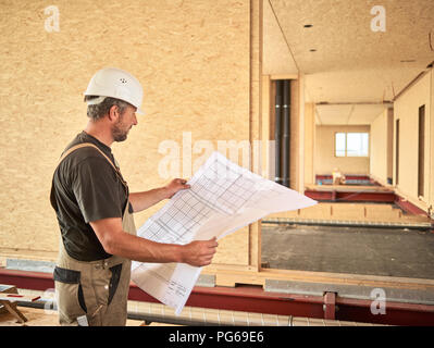 Worker with helmet holding construction plan Stock Photo