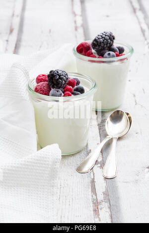 Two glasses of Greek yogurt with frozen berries Stock Photo
