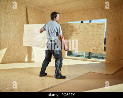 Worker carrying flakeboard Stock Photo