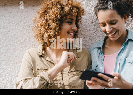 Best friends in the city using smartphone Stock Photo