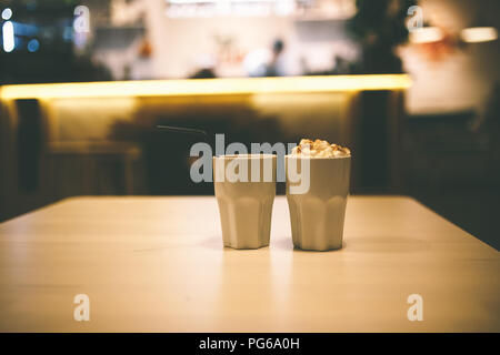 cocoa with marshmallows in a white Cup in a cafe on wooden table Stock Photo