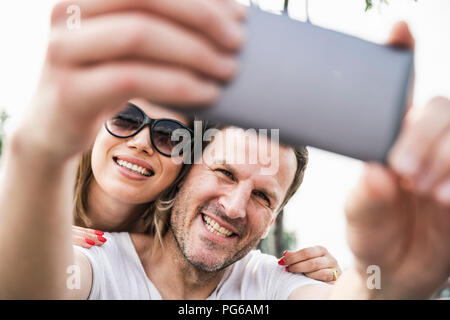 Happy couple taking a selfie outdoors Stock Photo
