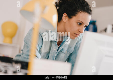 Businesswoman working at PC, looking focused Stock Photo