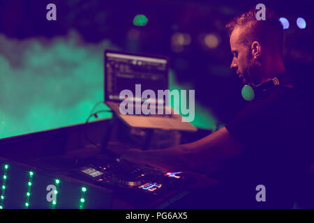 Dj mixes the track in the nightclub at party. DJ hands in motion Stock Photo