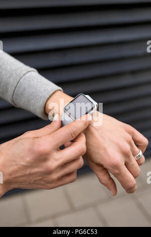 Woman's hand adjusting settings of smartwatch, close-up Stock Photo