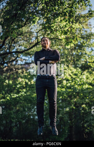 Young businessman levitating in park Stock Photo