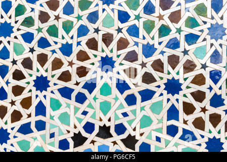 Islamic style tiles forming intricate geometric patterns with blue, white, green, brown and black pieces Stock Photo