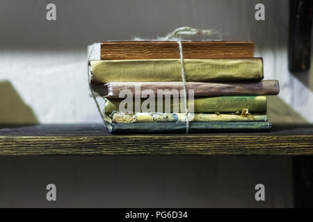 Stack of old books with golden covers on the shelf Stock Photo